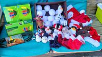 Full view of all lot contents including plush characters, snowballs, stockings, string lights, extension cord, and pet outfits arranged on a cushion.