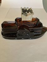 Brown glass steamboat bottle with detailed paddlewheel and white castle-shaped chimney.