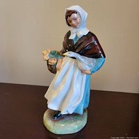 Front-side view showing the girl holding the goose and basket, highlighting the detailed painting and colors.
