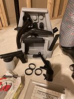 Kirby vacuum attachments including hose, crevice tool, upholstery tool, spray bottle, connector rings, all arranged on a plastic display stand.