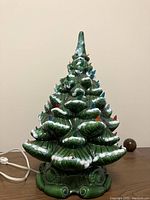 Front view of retro ceramic Christmas tree with colored bulb lights and snow accents.