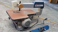 Full view of the Ryobi 16" scroll saw showing rust on table surface and attached power cord.