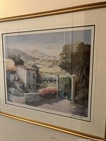 Front view of framed print showing entire artwork with landscape featuring village, trees, and hills