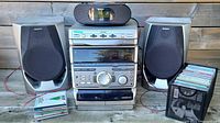 Full setup of Sony RXD5 stereo system with speakers and CD clock radio on wooden surface, CDs stored beside in holders