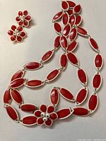 Red vintage necklace with matching red floral clip-on earrings featuring white bead centers