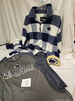 Photo of Penn State plaid sherpa quarter-zip jacket, Nittany Lions long sleeve shirt, and Penn State garden stone all displayed together