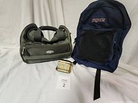 Photo showing Impuls travel bag, Jansport backpack, and Elgin folding travel clock together on white background.