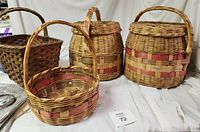 Four vintage woven baskets arranged showing round floor baskets with lids and handles, rustic willow basket, and small open basket