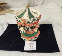 Front and slightly top angle view of vintage musical teddy bear carousel showing upper portion and base details including bears and decorative trims.