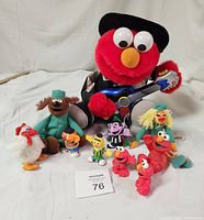 Photo showing all items in the lot including the plush Elmo with guitar and the assorted small Sesame Street PVC figurines and plush Muppets.