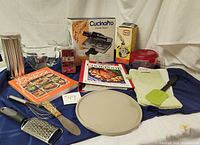 Whole lot arranged showing all baking and cooking items with cookbooks, utensils, and kitchen tools.