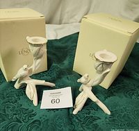 Two Lenox porcelain bird-shaped candle holders displayed on green fabric with their original cream-colored Lenox boxes behind them.