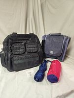 Side angle of Lug travel bag with quilted pockets, Boa Cay toiletry bag, and two umbrellas on the side.