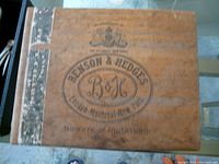 Top view of the wooden Benson & Hedges cigar box showing printed branding and tax band.