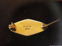 Close-up of the back of the gold pin showing hallmark and clasp