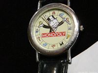 Close-up of watch face showing Monopoly character dial and logo