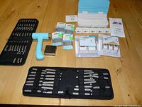 Full view of the lot showing the letter stamping sets in fabric cases, hammer, stamping blanks, punch board, and accessories on a wooden surface.