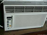 Close-up photo of LG air conditioner front panel showing the digital temperature display, control buttons, and vent louvers.