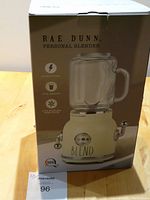 Packaged Rae Dunn personal blender box showing the blender graphic and basic specs including 300 watt power, 17 oz capacity, and 4 stainless steel blades.