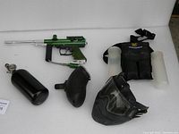 Full paintball gear lot with Spidervector 2 paintball marker, air tank, hopper, mask, harness pack, and paintball pods.