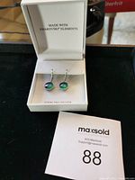 Pair of sterling silver earrings with iridescent Swarovski crystals inside a white jewelry box labeled 'Made with Swarovski Elements' and 'Sterling Silver'