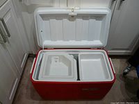 Photo of the cooler open, showing the two white insert trays inside, one deep and one shallow.