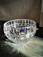 Photo of round crystal bowl with wedge cut grid pattern and Marquis Waterford label on the side.