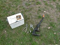 Overall photo showing the wooden box labeled 'Snaps', rivet tools, rivet pliers, and large hand clamp lever tool on grass.