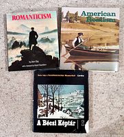 Front covers of three hardcover art books titled Romanticism, American Realism, and A Bécsi Képtár
