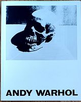 Front cover of the softcover book titled 'ANDY WARHOL' featuring a black-and-white skull artwork.