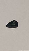 Close-up photo of the pear-shaped blue-green sapphire showing color and shape.