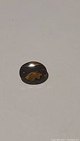 Photo of the oval cut Madeira citrine gemstone showing its deep cognac color and clarity.