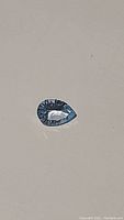 Pear cut natural sky blue topaz gemstone with fancy concave cut surface, showing strong light reflection and clarity.