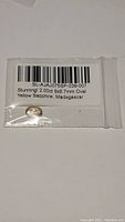 Photo of sapphire in a sealed plastic bag labeled as 2.00ct 9x6.7mm Oval Yellow Sapphire from Madagascar