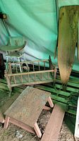 Photo of wooden bassinet/rocker, small picnic bench, and ironing board showing worn condition and rustic finish