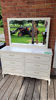 Front view of dresser and mirror against brick background