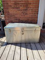 Front and top view of aluminum steamer trunk showing overall condition and riveted exterior.
