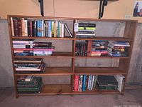 Front view of the wooden bookshelf filled with assorted books.
