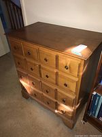 Angled view of the Vilas wood cabinet showing the top, one side, and drawer fronts.