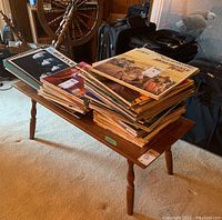 Full view of the wood coffee table loaded with vinyl records to show size and surface area.