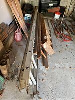 Full view of the Featherlite 24ft aluminum extension ladder placed near other tools and wood pieces.
