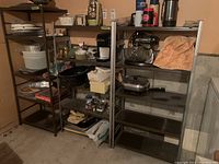 Photo of three metal utility shelf units with household items such as pots, pans, containers, and small appliances on shelves in basement setting.