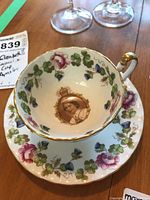 Tea cup and saucer set showing the floral design and cup shape with gold rim and handle.
