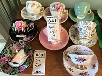 Eight tea cups and saucers displayed on table