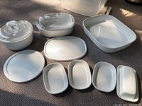 All CorningWare French White dishes and the butter dish laid out on floor