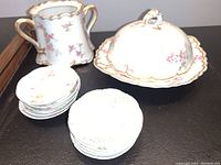 Photo showing 2-handled vase or sugar bowl, 10 bone dishes stacked, and covered butter dish in background