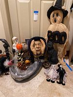 Full view of Halloween decorations on the floor showing ghost with BOO hat, black cat, stuffed dolls and a mask