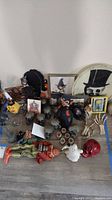 Overhead shot showing assorted Halloween decorations including skull figurines, paperboard silhouettes, framed prints, shot glasses and ghost figure
