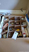 Overall view of boxed collection showing multiple small compartments each containing different bottles and holders