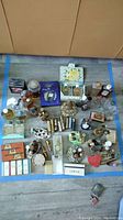 Overview of multiple perfume bottles, boxes, and related items arranged on floor.